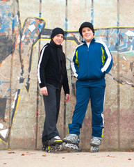 Naklejka na ściany i meble Teenage boys on roller skates posing outdoor