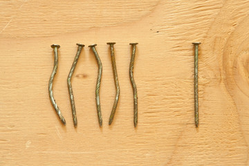 Conceptual image of crooked nails and straight nail