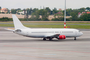 White passenger airplane taxiing on the runway