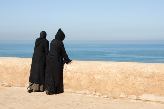 Moroccan women looking out over the ocean