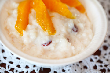 Milk rice pudding with raisins and orange slices, top detail