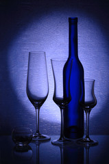 Three wineglasses, a candlestick and a bottle