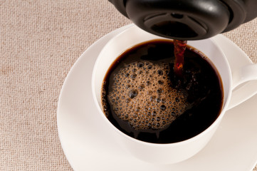 Black expresso in a white coffee cup on canvas background