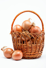 Fresh bulbs of onion in basket on a white background