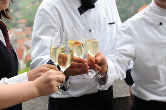 Mit Sekt ansto&szlig;en - Koch und Servicepersonal nach der Arbeit