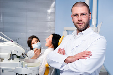 Male dentist with assistant and patient at dental clinic