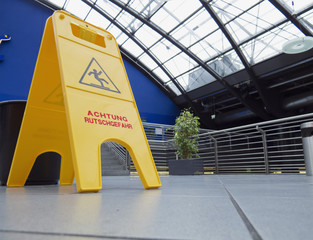 yellow warning sign on the floor after cleaning the tiles