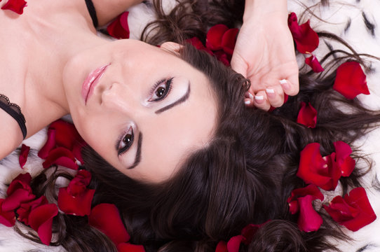 Beautiful sexy girl with rose petal in hears. Studio shot.