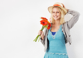 Lachende Frau mit Sonnenhut und Blumenstrauss