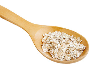 Rolled oats in spoon on white
