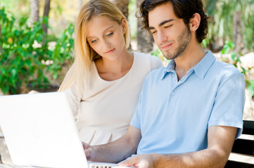 Young couple working on laptop and smiling