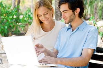 Young couple working on laptop and smiling