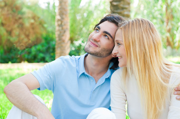 Romantic young couple sitting together in summer park