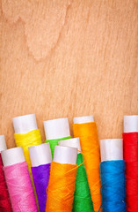 Sewing thread reels on a wood background