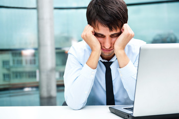 Tired businessman sleeping at his desk in the office
