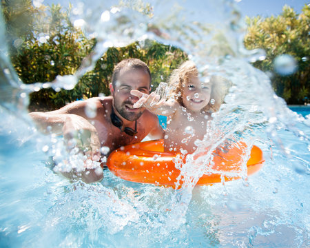 Child with father in swimming pool