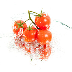 five fresh cherry tomatoes in water splash