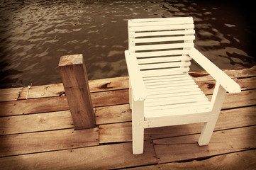 Fototapeta na wymiar wood chair against water pool