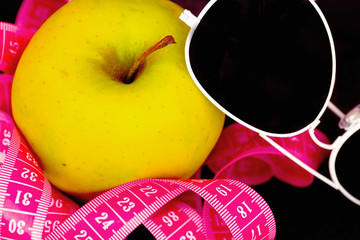 dieting for summer: apple, sunglasses, measuring tape