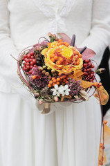 Bride holding beautiful orange wedding flowers bouquet