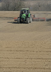 Obraz premium Un agriculteur dans son tracteur en train de préparer la terre