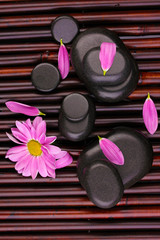 Obraz na płótnie Canvas Spa stones and flower on bamboo mat