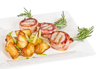Grilled steak wrapped in bacon, with grilled vegetables
