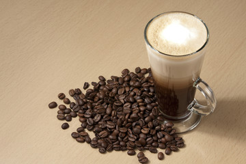 Coffee with froth and coffee beans below. Horizontal
