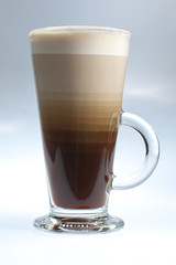 Layered white coffee in glass on the white/azure background
