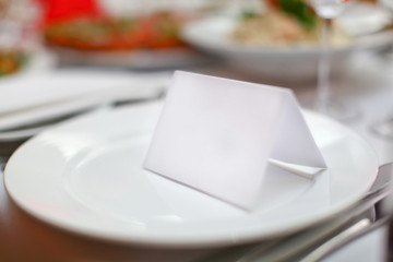 Blank plate and card for guests in restaurant - obrazy, fototapety, plakaty