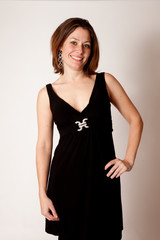 Fototapeta premium Pretty brunette smiling at the camera with hand on hip