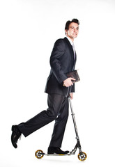 successful man in business suit who rides a scooter