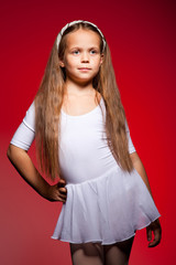 Little ballet dancer isolated on a red background