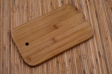 Obraz na płótnie Canvas Wooden Bread board on wooden bamboo background