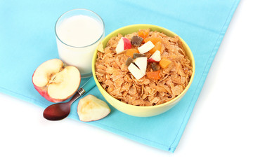tasty cornflakes in bowl with dried fruits, glass of milk and