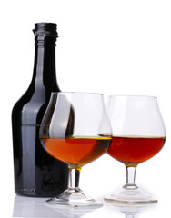 Glasses of brandy and bottle isolated on white