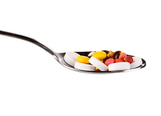 Spoon with pills isolated on white