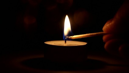 Burning candle by match