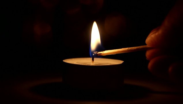 Burning candle by match