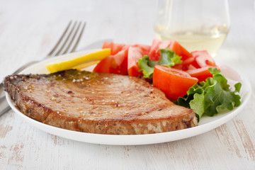 fried tuna with salad and lemon on the plate