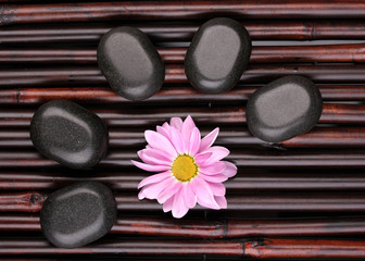 Obraz na płótnie Canvas Spa stones and flower on bamboo mat
