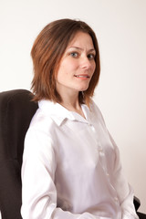 brunette in white shirt smiling at the camera