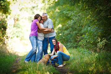 Fototapeta premium Family portrait - Family of four with a cute dog outdoors