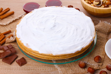cake on glass stand and nuts on wooden  table