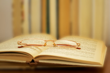 glasses lying on the open book