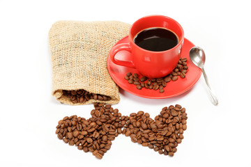 Heart made ​​from coffee beans around a cup of coffee on a w