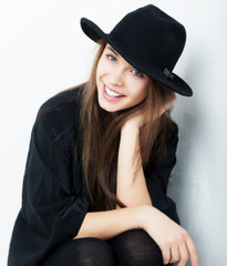 Beautiful portrait of smiling stylish young woman in black hat