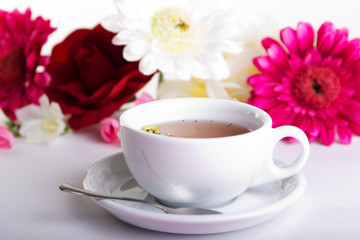 Obraz na płótnie Canvas Cup of tea with flower on table