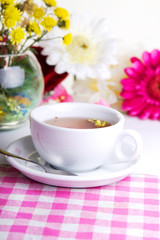 Fototapeta na wymiar Cup of tea with flower on table