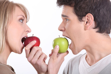 Man and woman about to bite into apples